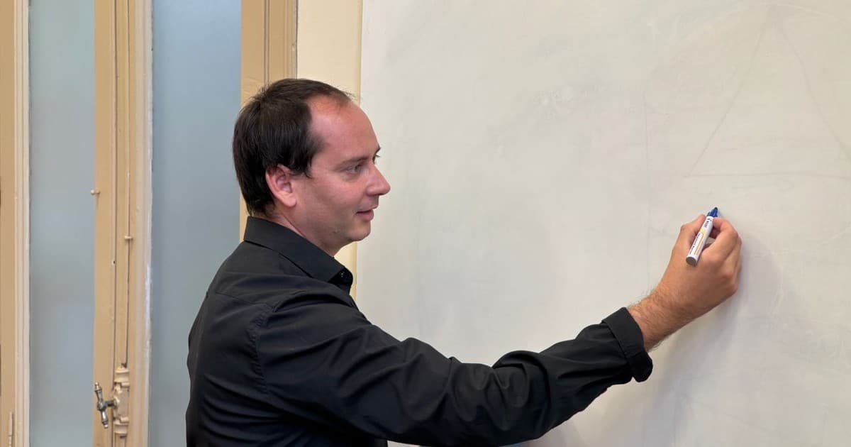 Instructor writing on a whiteboard during a live cohort learning session